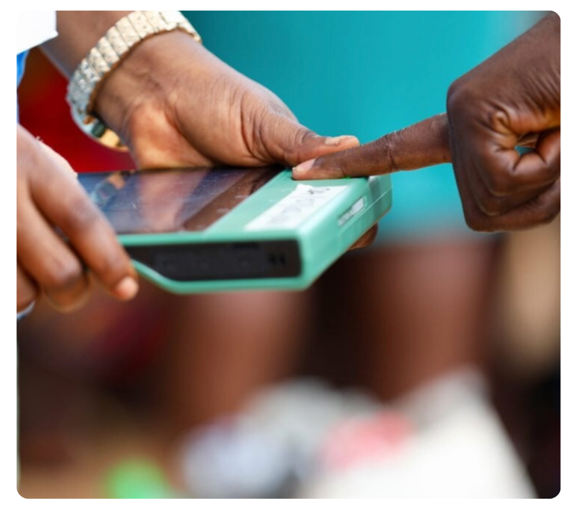 An INEC official using the BVAS device to capture a voter's fingerprint at a polling unit